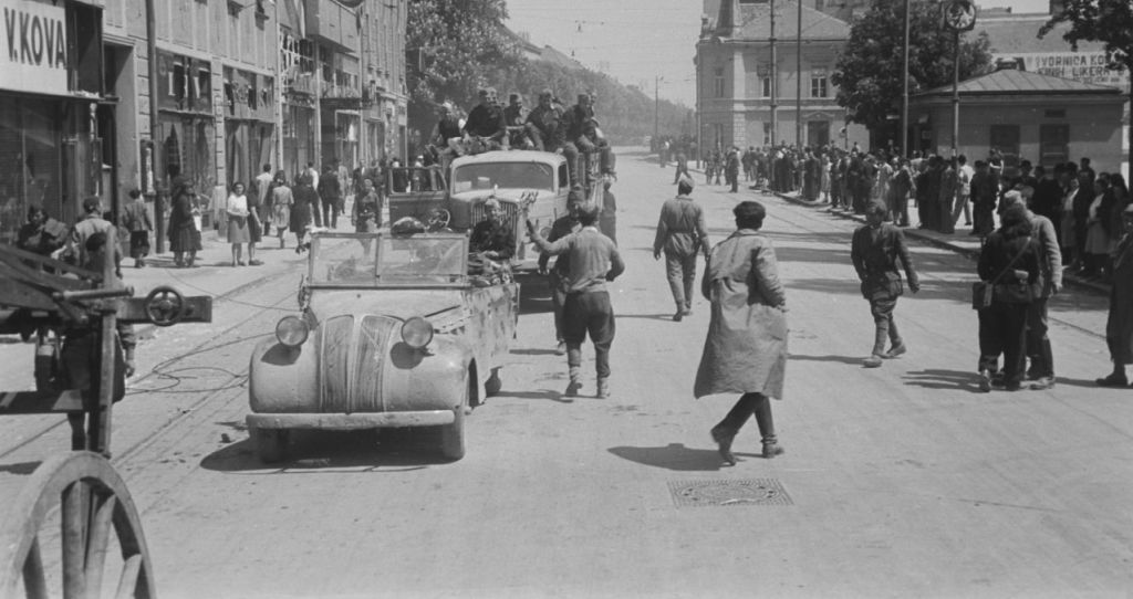Zagreb, 9. svibnja 1945. godine. Jedna partizanska štabna kola i kamion Opel Blitz zaustavili su se na Kvaternikovom trgu